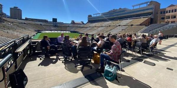 Group of science writers outside at Folsom Field
